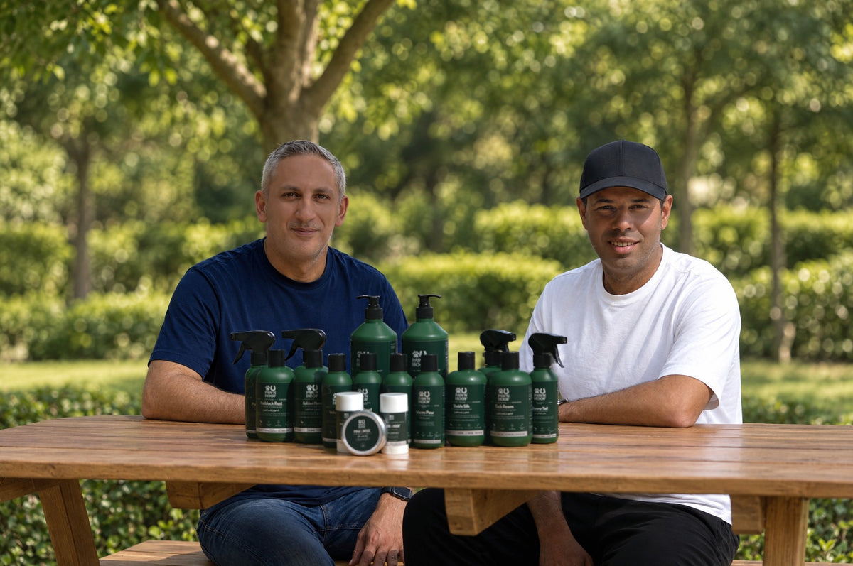 Paw N Hoof founders Mohamed Awad and Mohamed Abou Shousha seated at a table with the full range of horse and dog care products